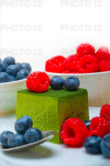 Green tea matcha mousse cake with raspberries and blueberries on top