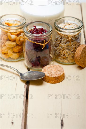 Healthy breakfast ingredients milk oat cashew nuts dried cramberry craisinns