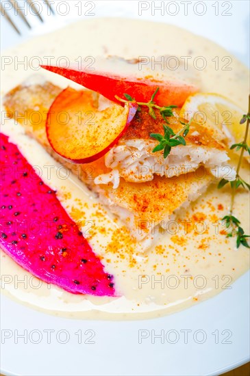 Sea bream orata fillet butter pan fried with fresh peach prune and dragonfruit slices thyme on top