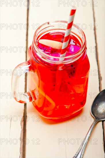 Fresh fruit punch refreshing summer drink over white rustic wood table