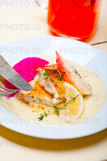 Sea bream orata fillet butter pan fried with fresh peach prune and dragonfruit slices thyme on top