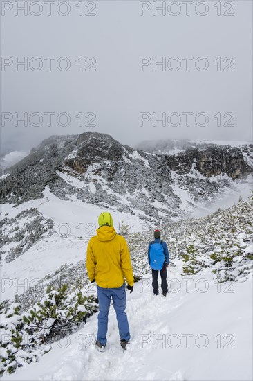 Two hikers on a hiking trail in the snow