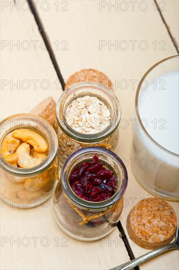 Healthy breakfast ingredients milk oat cashew nuts dried cramberry craisinns