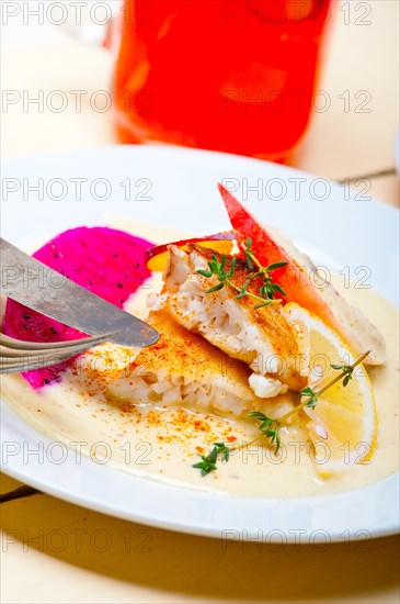 Sea bream orata fillet butter pan fried with fresh peach prune and dragonfruit slices thyme on top