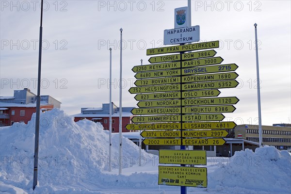 Signposts in front of snow masses in the centre of Haparand