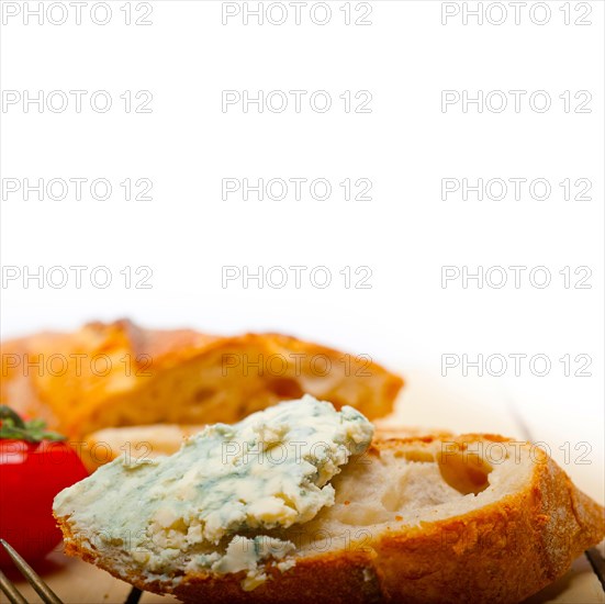 Fresh blue cheese spread ove french baguette with cherry tomatoes on side