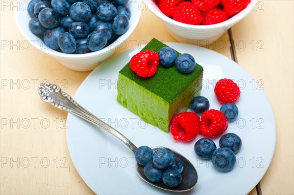 Green tea matcha mousse cake with raspberries and blueberries on top