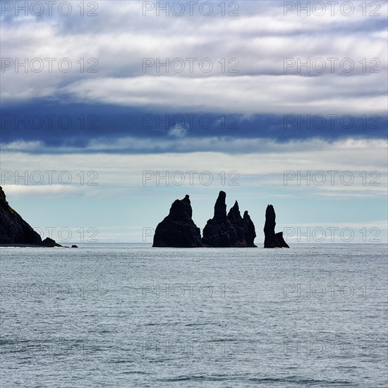 Cloudy sky above rock needles Reynisdrangar in summer