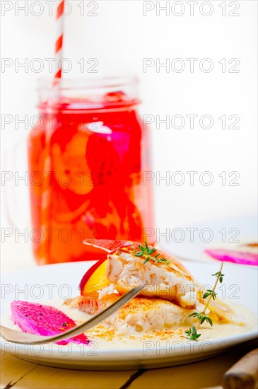 Sea bream orata fillet butter pan fried with fresh peach prune and dragonfruit slices thyme on top