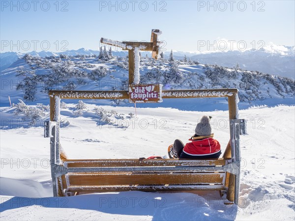 Tourist enjoying the view of snow-covered peaks from the mountain station at Lawinenstein