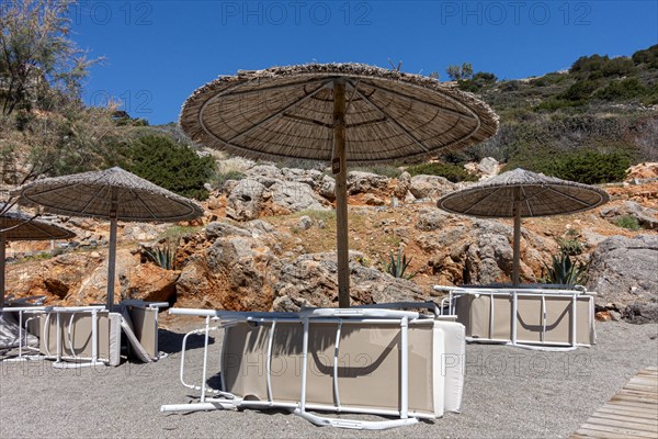 Inverted parasols and sun loungers on the beach