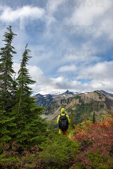 Hiker in front of Mt. Baker in clouds with snow and glacier