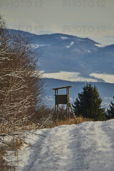 Hunters blind in a snowy landscape next to the forest