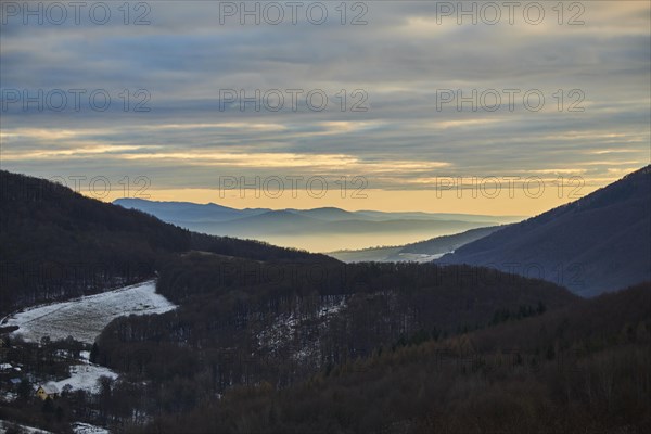 Fog lying in a valley at sunset