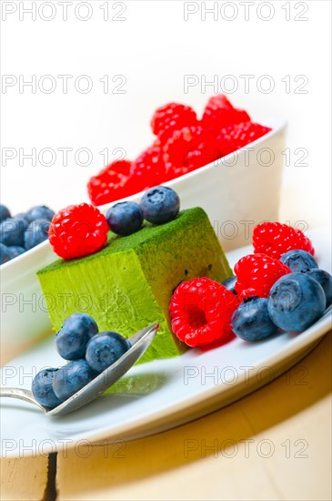 Green tea matcha mousse cake with raspberries and blueberries on top