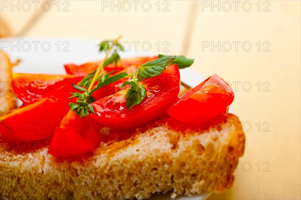 Italian tomato bruschetta with thyme and mint leaves