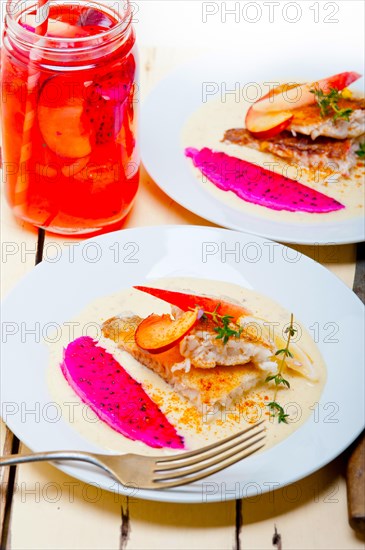 Sea bream orata fillet butter pan fried with fresh peach prune and dragonfruit slices thyme on top