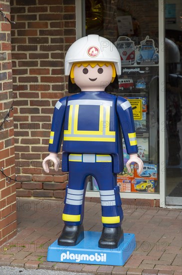 Giant Playmobil character model outside toy shop