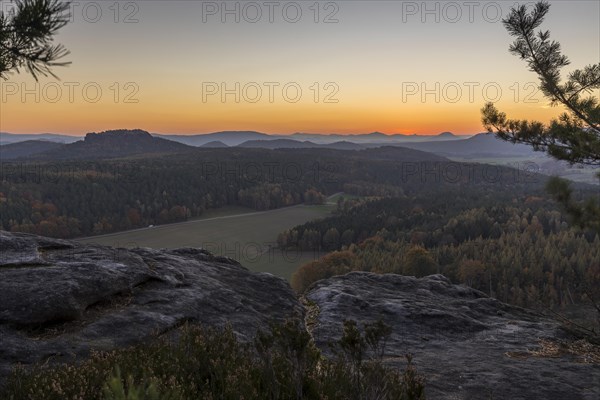 Rocks and vantage point on Pfaffenstein with view of Table Mountain Gohrisch at sunrise