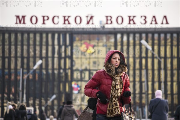 A beautiful young woman walking in front of the harbour in Vladivostok