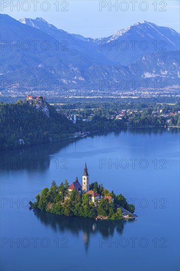 The island of Bled with its church on Lake Bled surrounded by the Julian Alps in Lake Bled