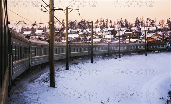 The trans-siberian railway bending on the rails passing through a small Siberian village covered in snow in Winter in the region of Irkutsk