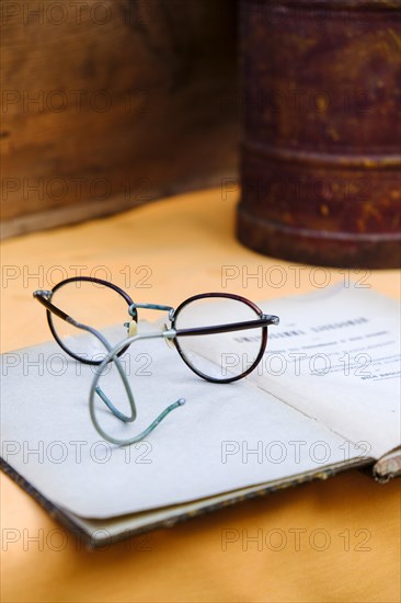 Old glasses on old book for sale at a flea market