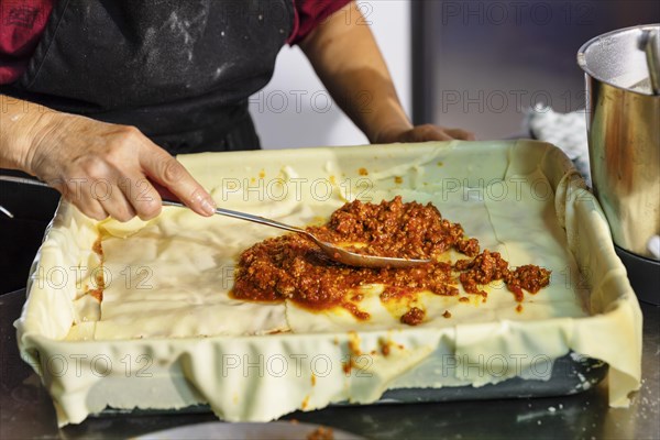 Preparing a lasagne in the kitchen of an agriturismo