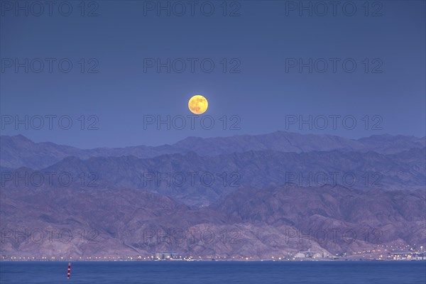 Afull moon over the desert of Akaba in Jordan as seen from the shores of Eilat