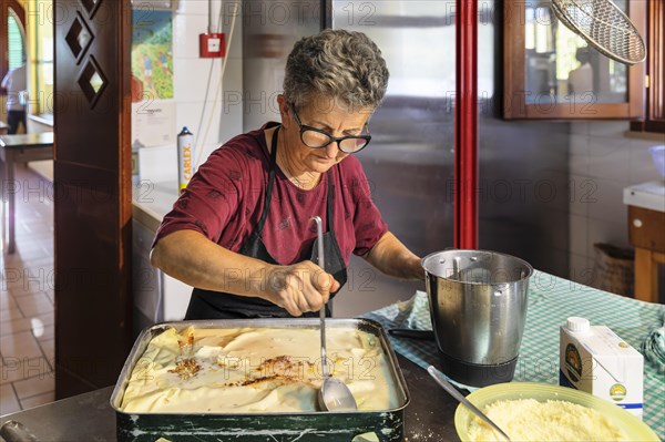 Preparing a lasagne in the kitchen of an agriturismo