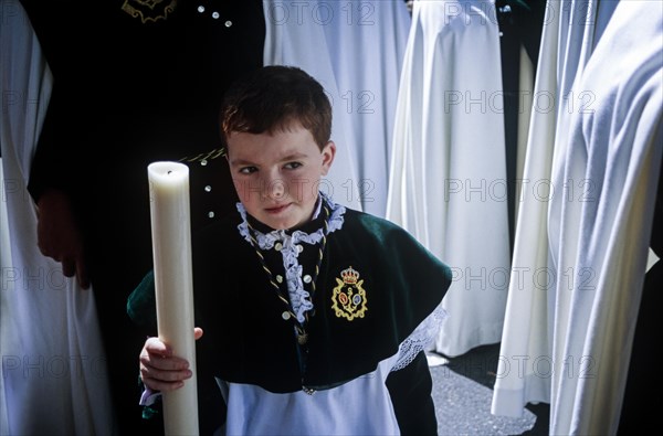 Achild in the respective brotherhood uniform during Semana Santa in Seville