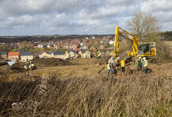 Workers and machinery doing groundwork new housing development