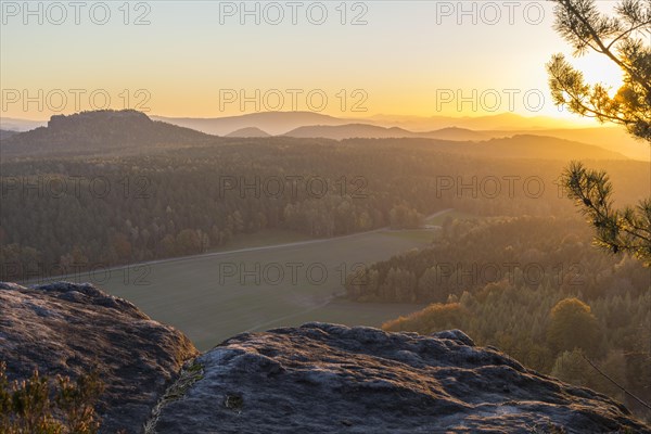 Rocks and vantage point on Pfaffenstein with view of Table Mountain Gohrisch at sunrise