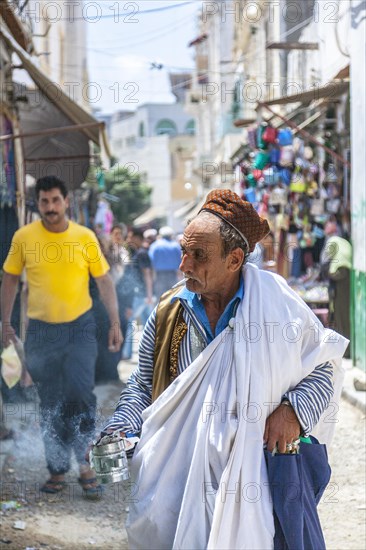 An elderly Berber in traditional clothes with incense
