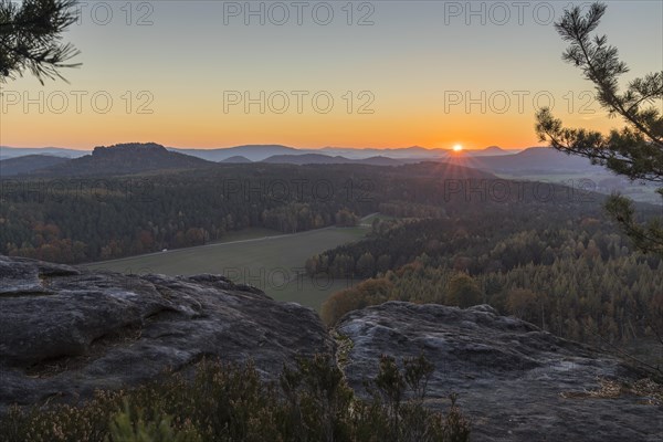 Rocks and vantage point on Pfaffenstein with view of Table Mountain Gohrisch at sunrise