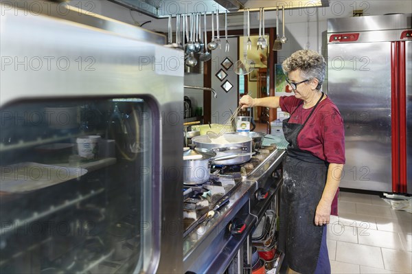 Preparing a lasagne in the kitchen of an agriturismo