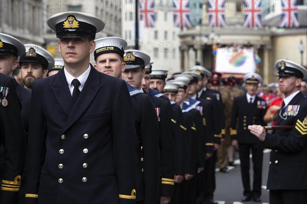 British navy participants enjoy the London Pride festival in brilliant sunshine under Union Jacks. London