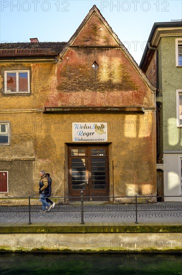 Old facade with pointed gable on the city stream