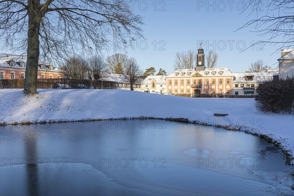 Gatehouse and castle park with frozen pond of the Grossharthau manor