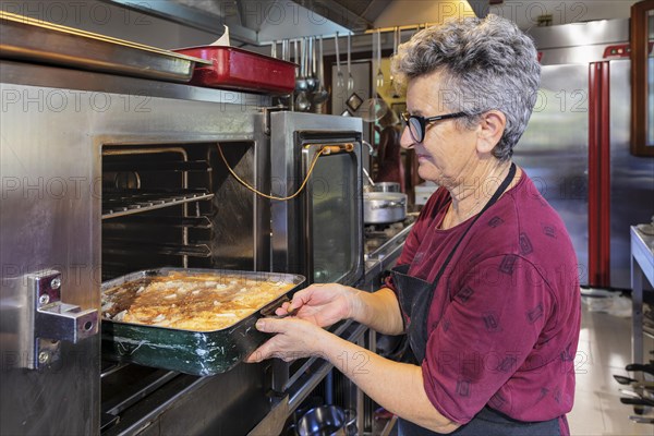 Preparing a lasagne in the kitchen of an agriturismo