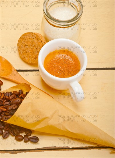 Espresso coffee and beans on a paper cone cornucopia over white background