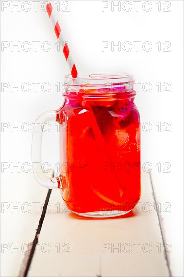 Fresh fruit punch refreshing summer drink over white rustic wood table