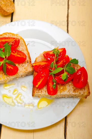 Italian tomato bruschetta with thyme and mint leaves