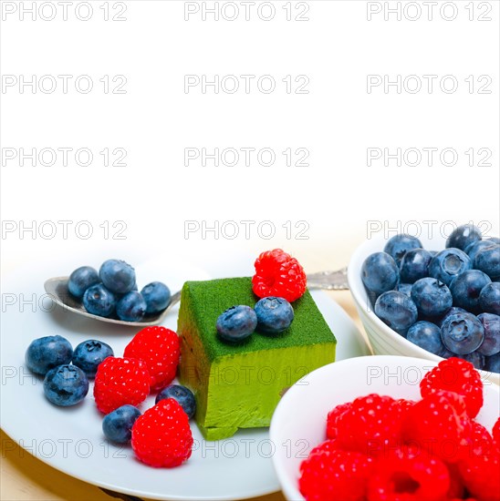 Green tea matcha mousse cake with raspberries and blueberries on top