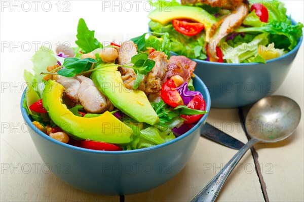 Fresh and healthy Chicken Avocado salad over rustic wood table