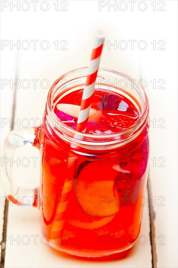 Fresh fruit punch refreshing summer drink over white rustic wood table