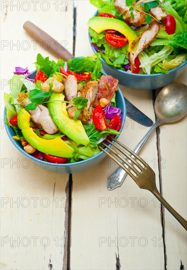 Fresh and healthy Chicken Avocado salad over rustic wood table