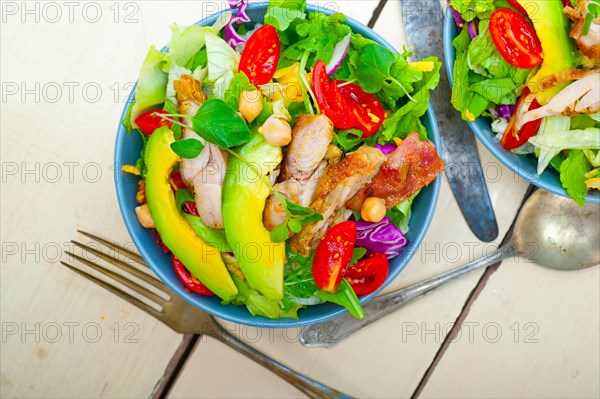 Fresh and healthy Chicken Avocado salad over rustic wood table