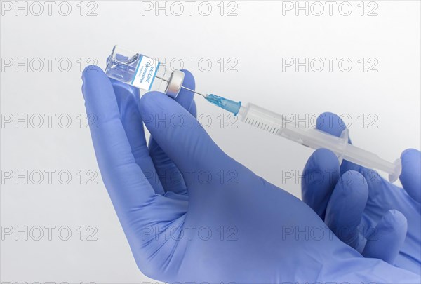 Doctor hands holding a vaccine bottle and syringe