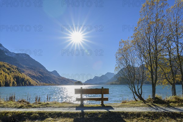 Lake Silsersee with bench and sun in autumn
